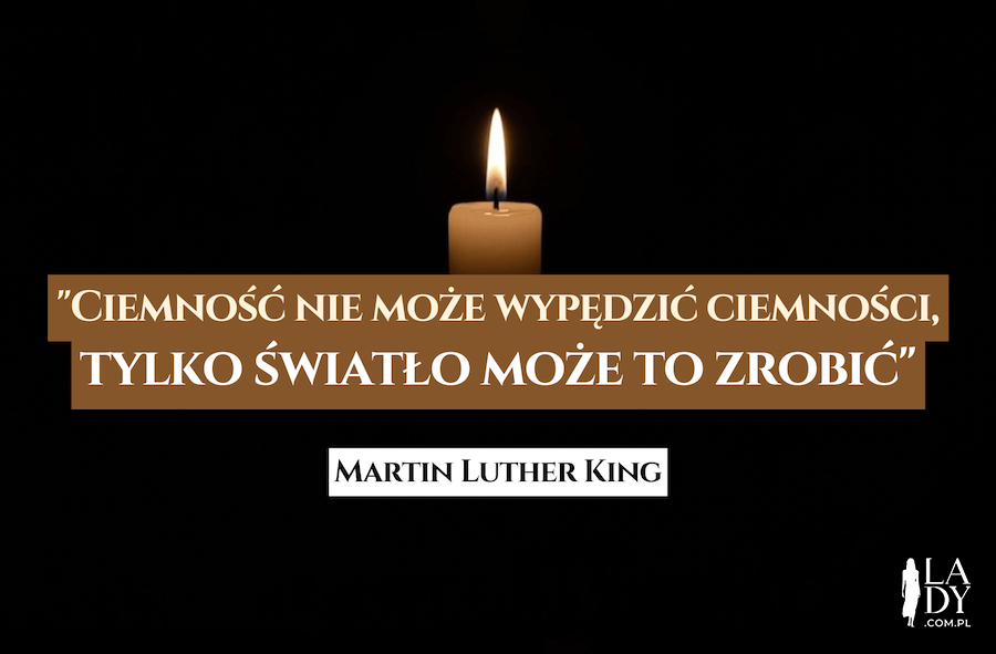 Płonąca pojedyncza świeczka w ciemności, z cytatem: Ciemność nie może wypędzić ciemności, tylko światło może to zrobić