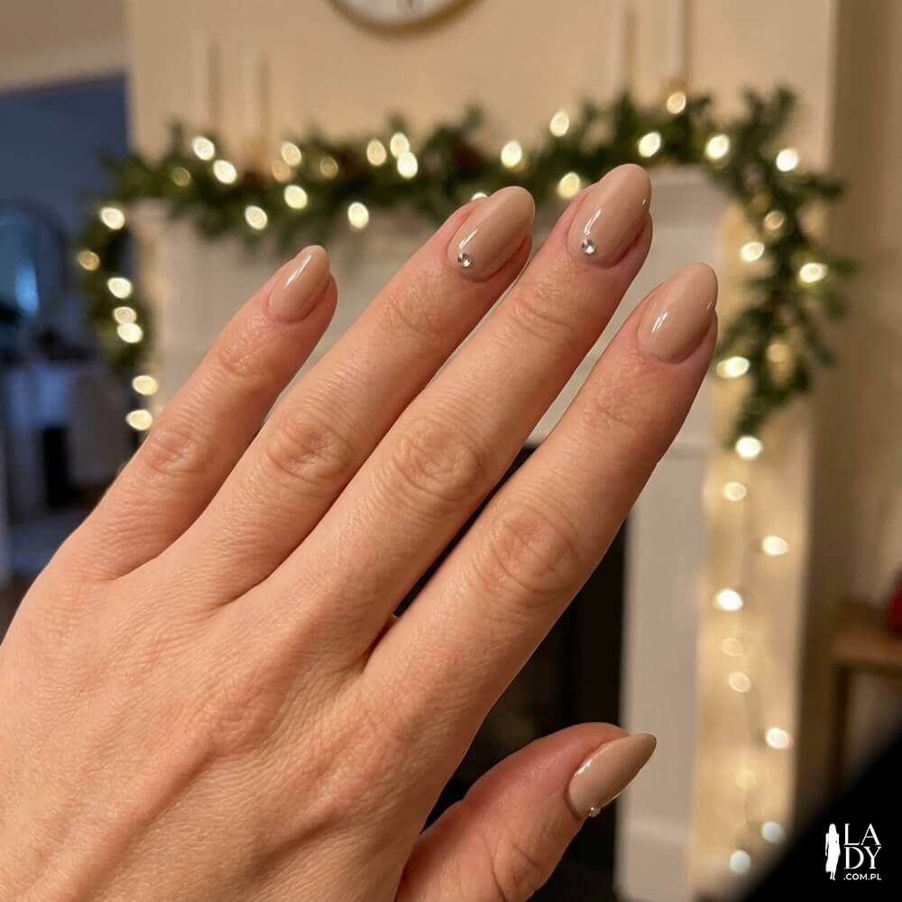 Delikatne beżowe paznokcie w stylu minimalistycznym z pojedynczą cyrkonią u nasady