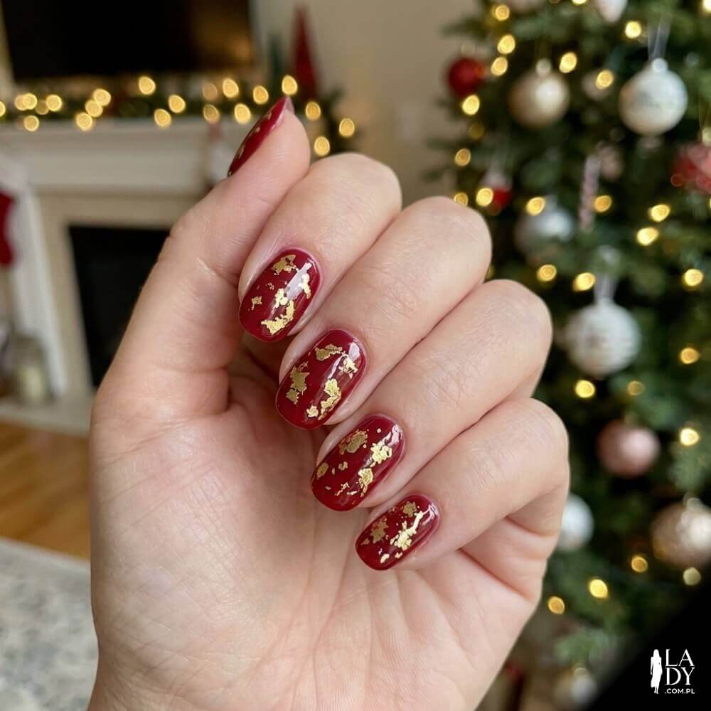 Czerwony manicure z artystycznie odbitą złotą folią transferową na jednym z paznokci