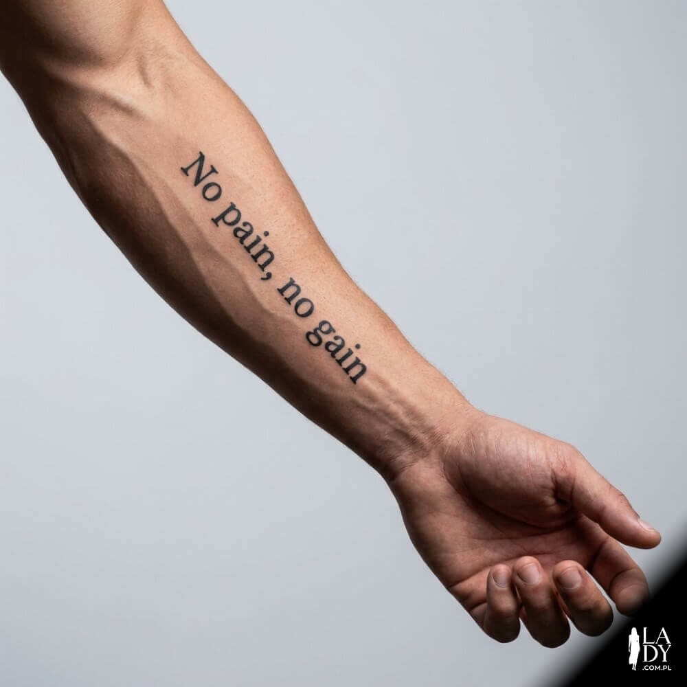 Męskie przedramię z tatuażem „No pain, no gain” w spójnym, studyjnym oświetleniu