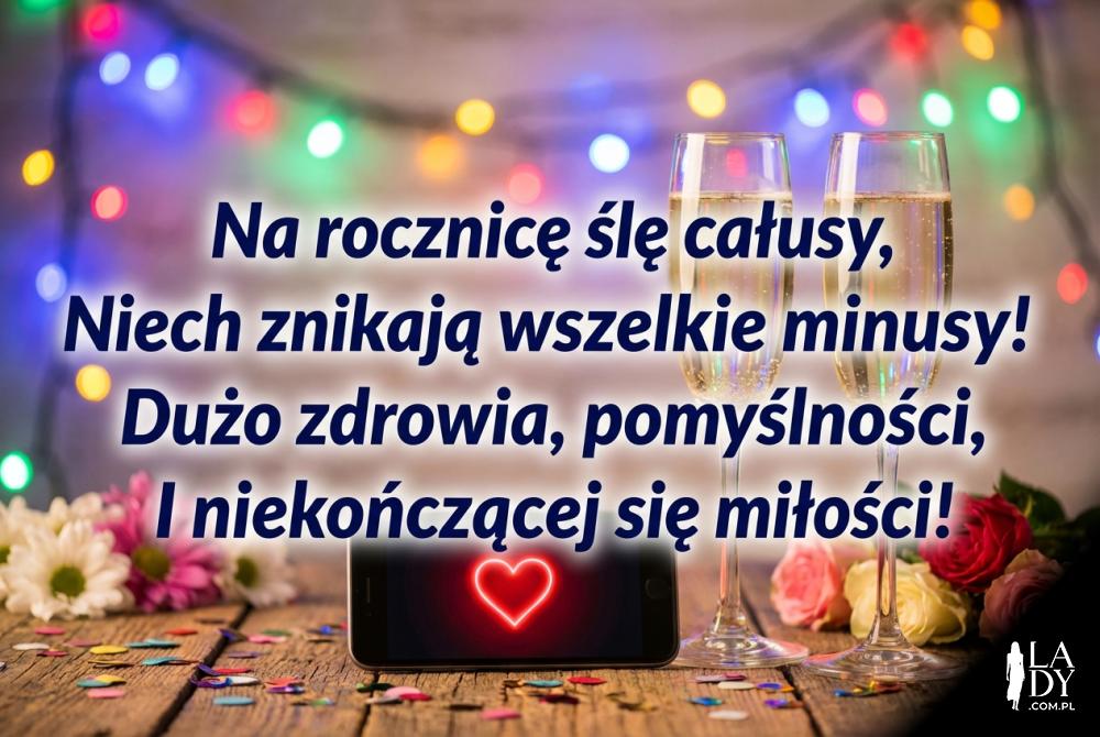 Smartfon z życzeniami i kieliszki szampana