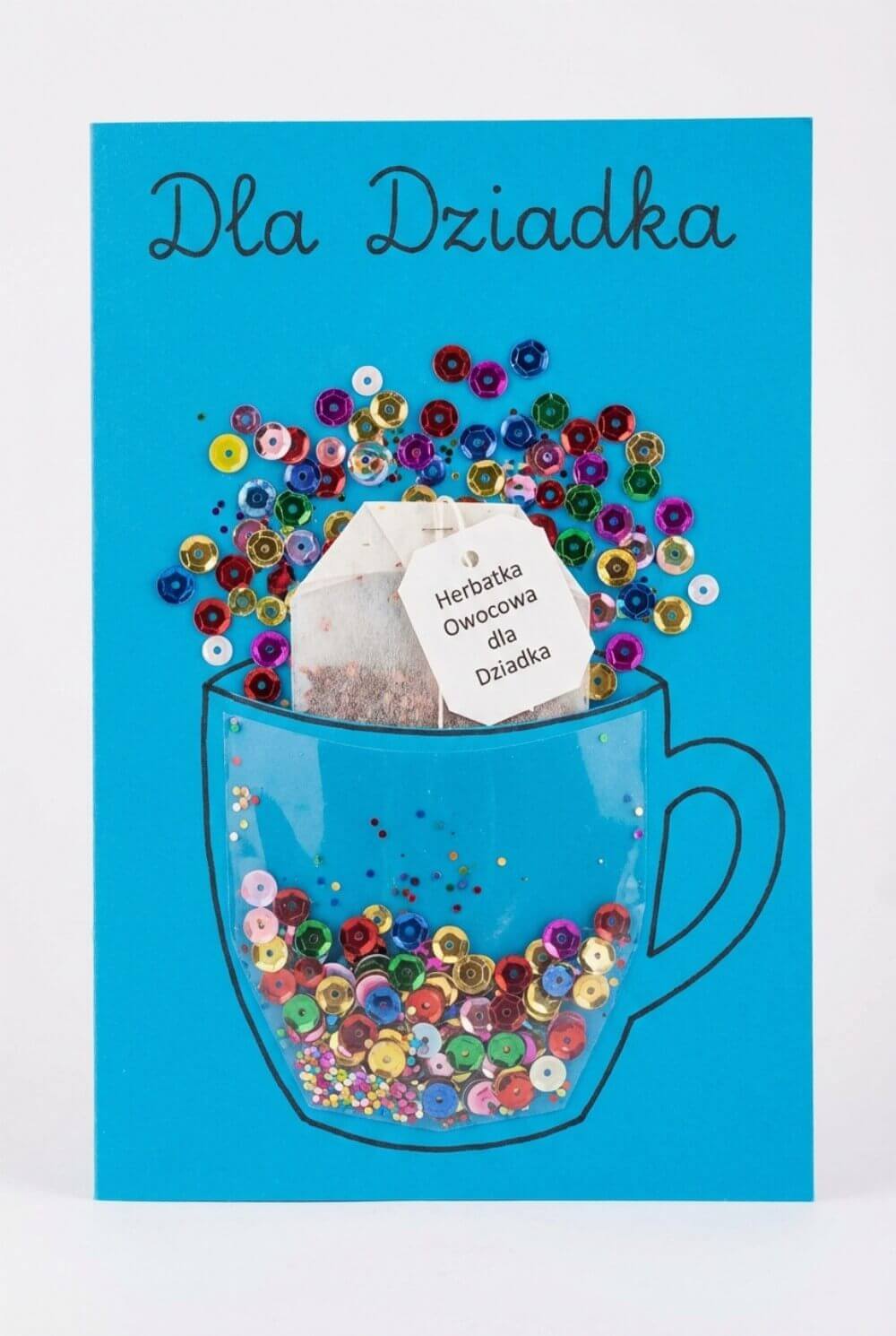 Niebieska laurka z motywem kubka ozdobionego cekinami i herbatą