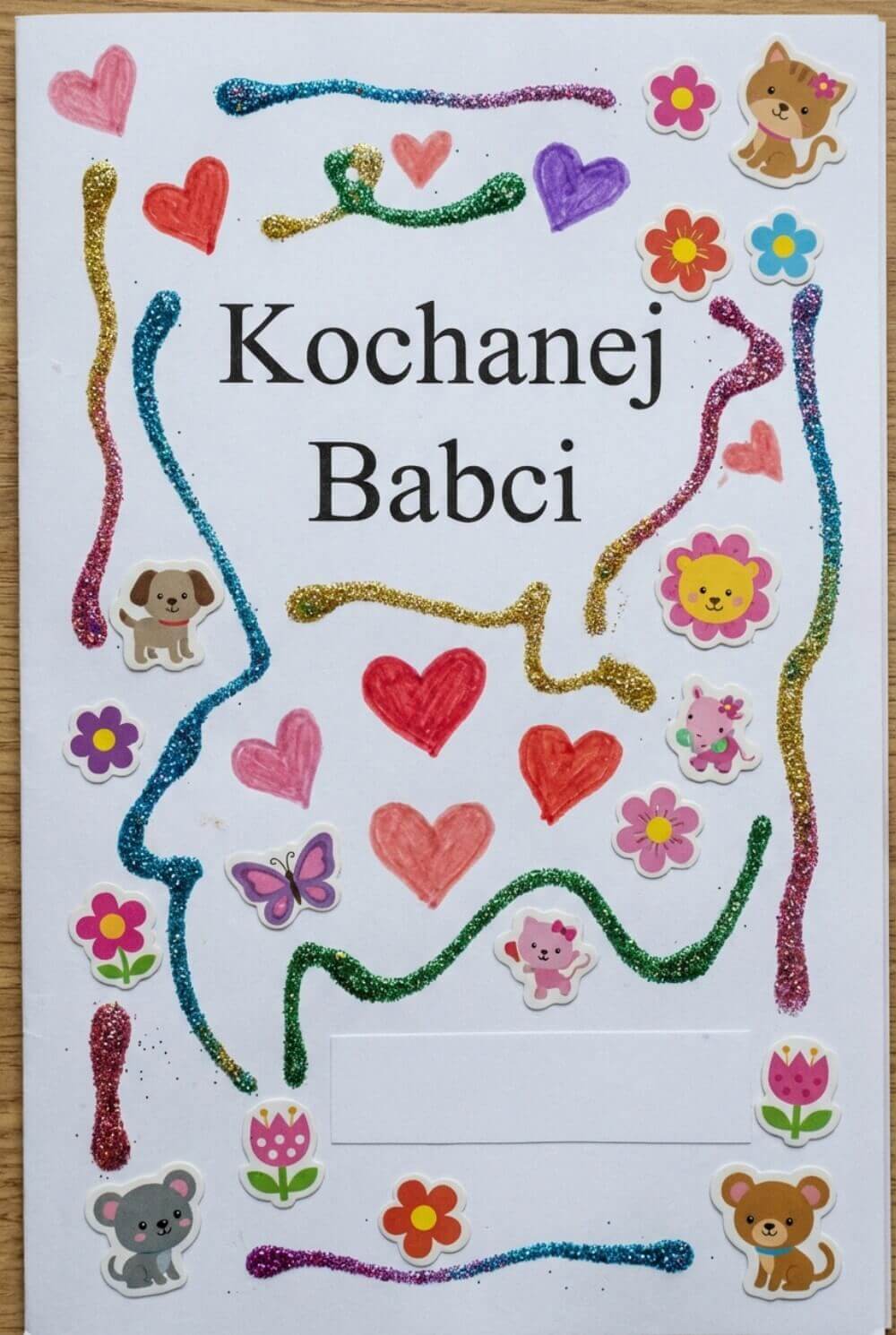 Wydrukowana laurka z napisem ozdobiona ręcznie brokatem